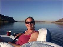 Rachelle Erlin floating in a boat on a sunlit lake